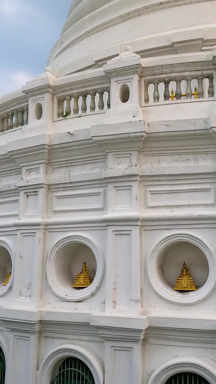 Un'esplorazione tranquilla degli stupa bianchi di Wat Prayurawongsawas a Bangkok, catturata con luce diurna soffusa e un movimento fluido della telecamera