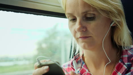 mujer en un tren usando un teléfono inteligente