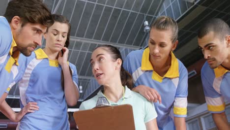 Female-trainer-giving-instructions-to-volleyball-players-4k