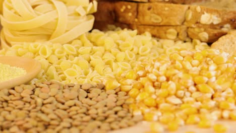 close-up of various grains and pasta arranged on a table, captured with warm lighting and soft focus for a cozy atmosphere