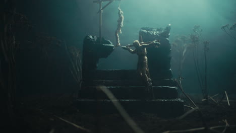 a miniature scene of the mummified dolls hanging on the gallows at night