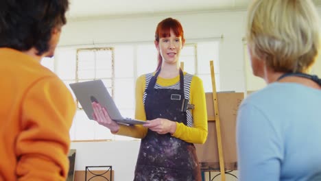 mujer interactuando con artistas mientras usa portátil 4k