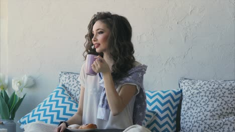 woman enjoying coffee and pastries by the window