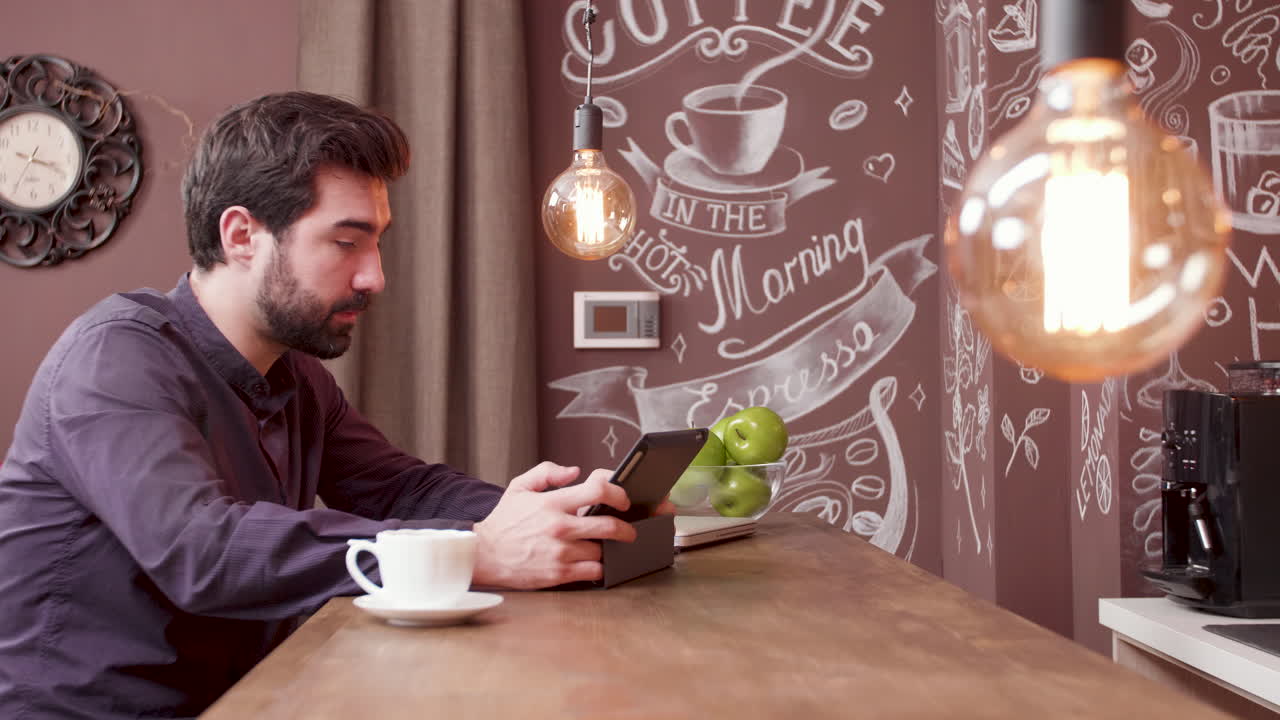 Uomo che usa il tablet in un caffè