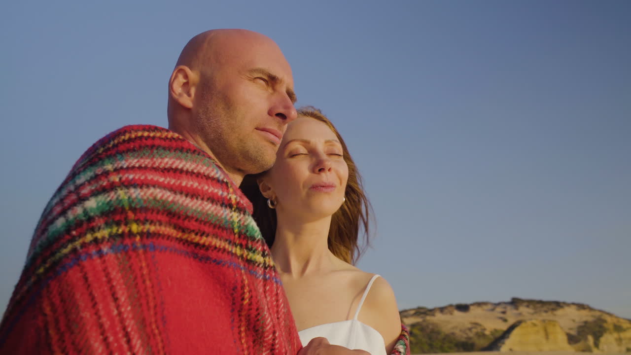 사랑에 빠진 행복한 커플이 해변을 바라보고 있습니다.