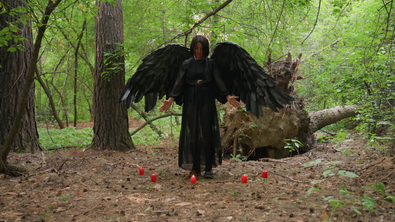 Black fairy witch with large dark wings stands among glowing red candles on forest floor, performing sacred ritual and silent prayers to ancient gods, surrounded by mystical green trees