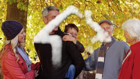 smoke forming a house shape against three generation caucasian family in the park