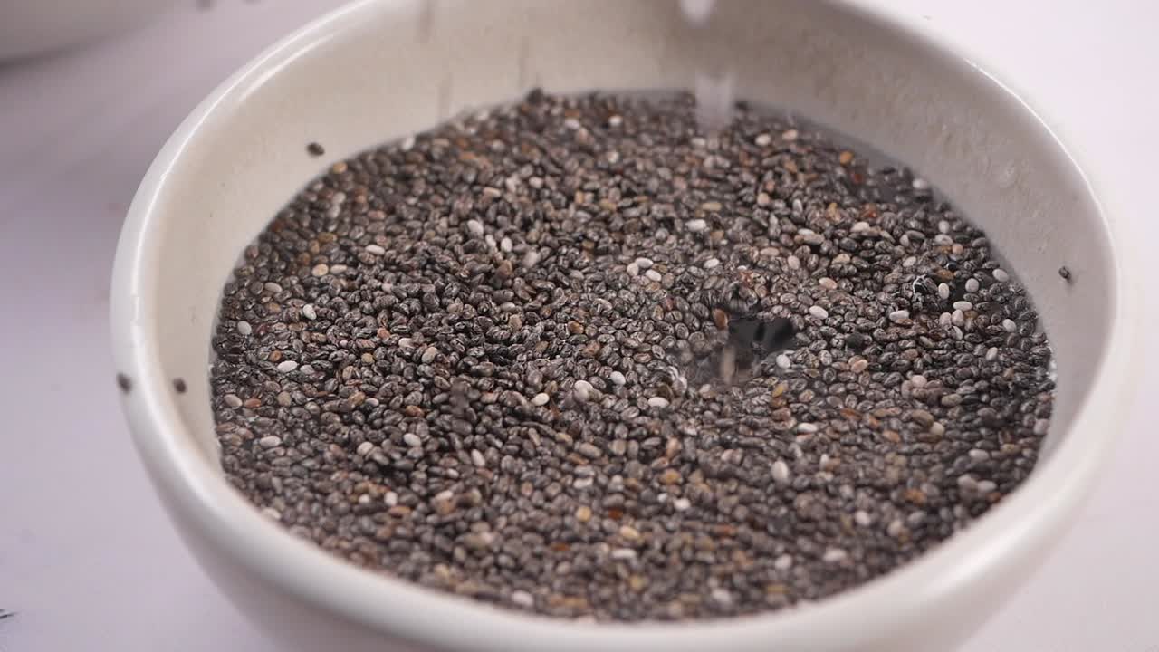 Versare acqua in una ciotola di semi di chia