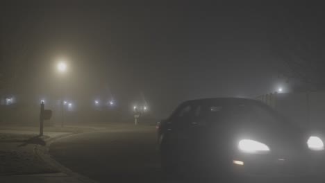 car driving on the foggy street through a residential neighborhood