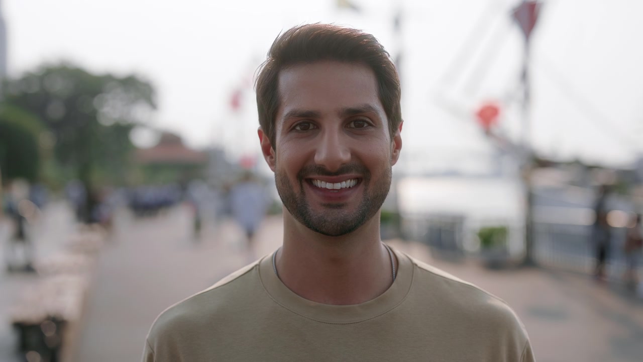 Ritratto di un giovane uomo allegro che sorride all'aperto