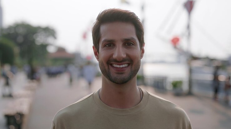 Ritratto di un giovane uomo allegro che sorride all'aperto