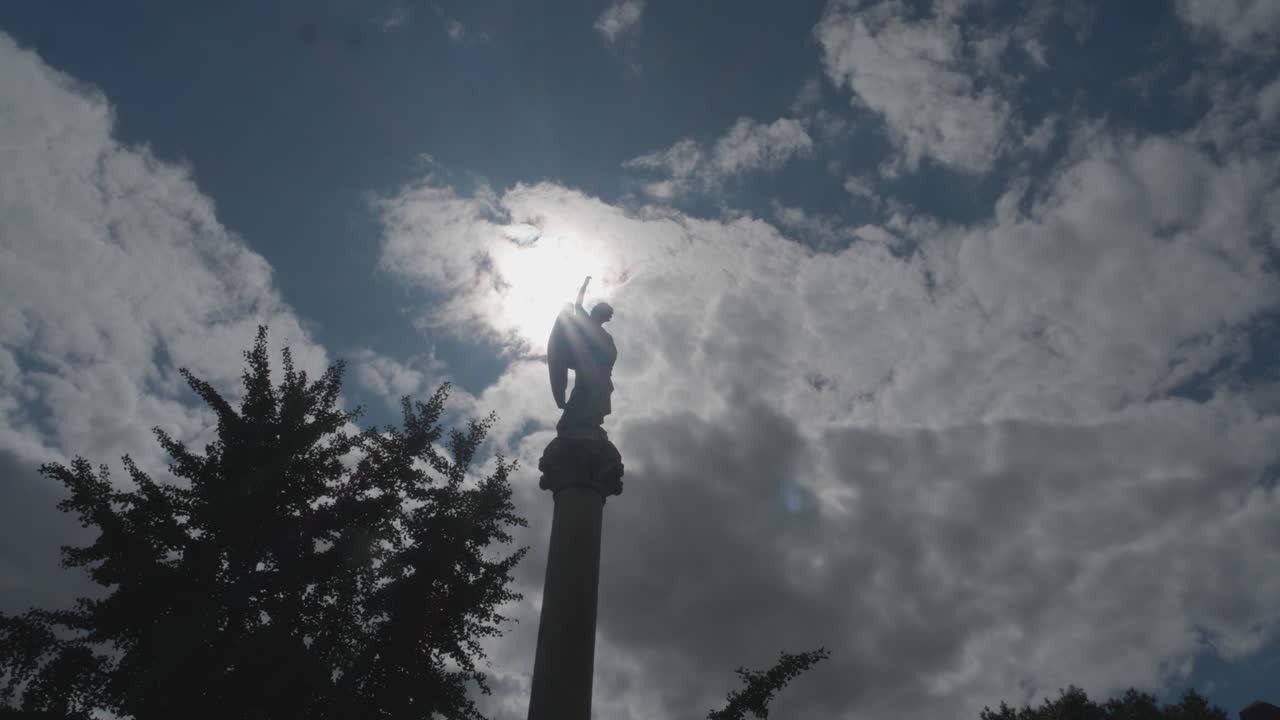 lapso de tiempo del sol-luna pasando detrás de la estatua del cementerio en el pilar
