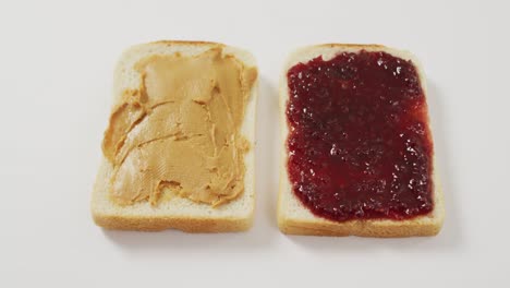 Close-up-view-of-peanut-butter-and-jelly-sandwich-with-copy-space-on-white-surface