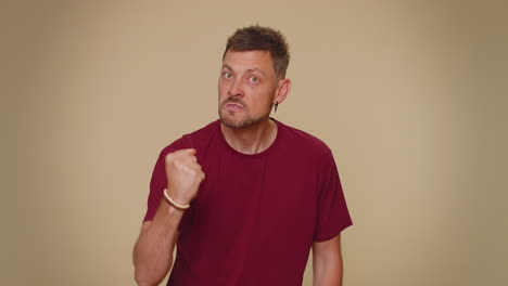 aggressive angry man trying to fight at camera, shaking fist, boxing with expression, punishment