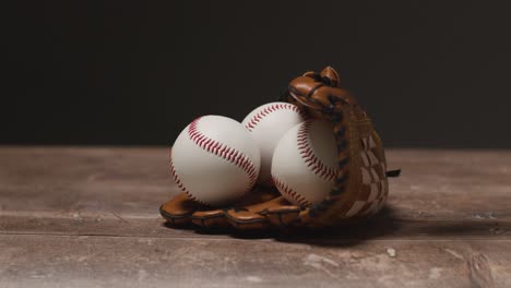 vida muerta de béisbol con persona recogiendo la pelota de los receptores guante en el suelo de madera