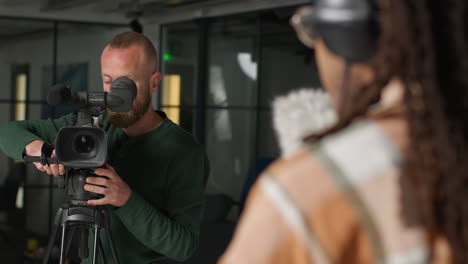 male sound recordist and camera operator working on film set shooting movie or video in studio 1