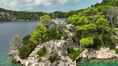 drone dolley shot over the rocks of mljet island with luxury yatchs moored in the bay