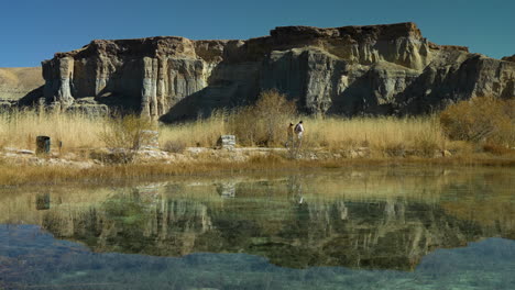 Reflejo-De-La-Gente-Caminando-Cerca-Del-Lago-En-El-Parque-Nacional-Band-e-Amir-En-Bamyan,-Provincia-De-Afganistán-Central