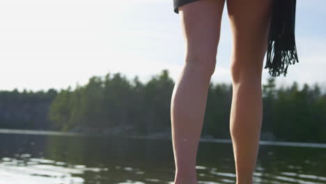 Fun-young-woman-walks-across-the-sand-and-into-the-lake