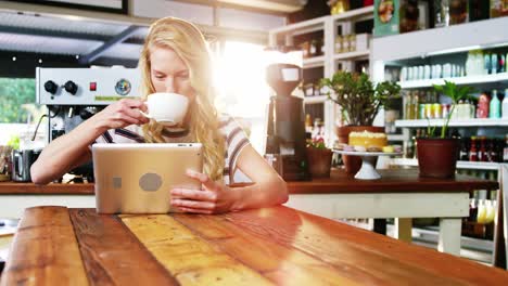Frau-Benutzt-Digitales-Tablet,-Während-Sie-Eine-Tasse-Kaffee-Trinkt
