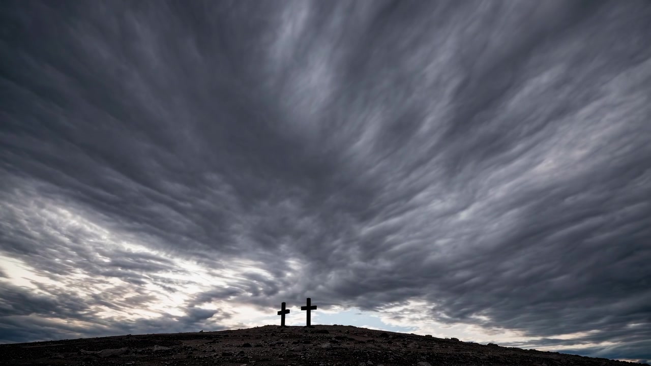 Two Wooden Crosses Standing on a Hill Under Dramatic Stormy Clouds