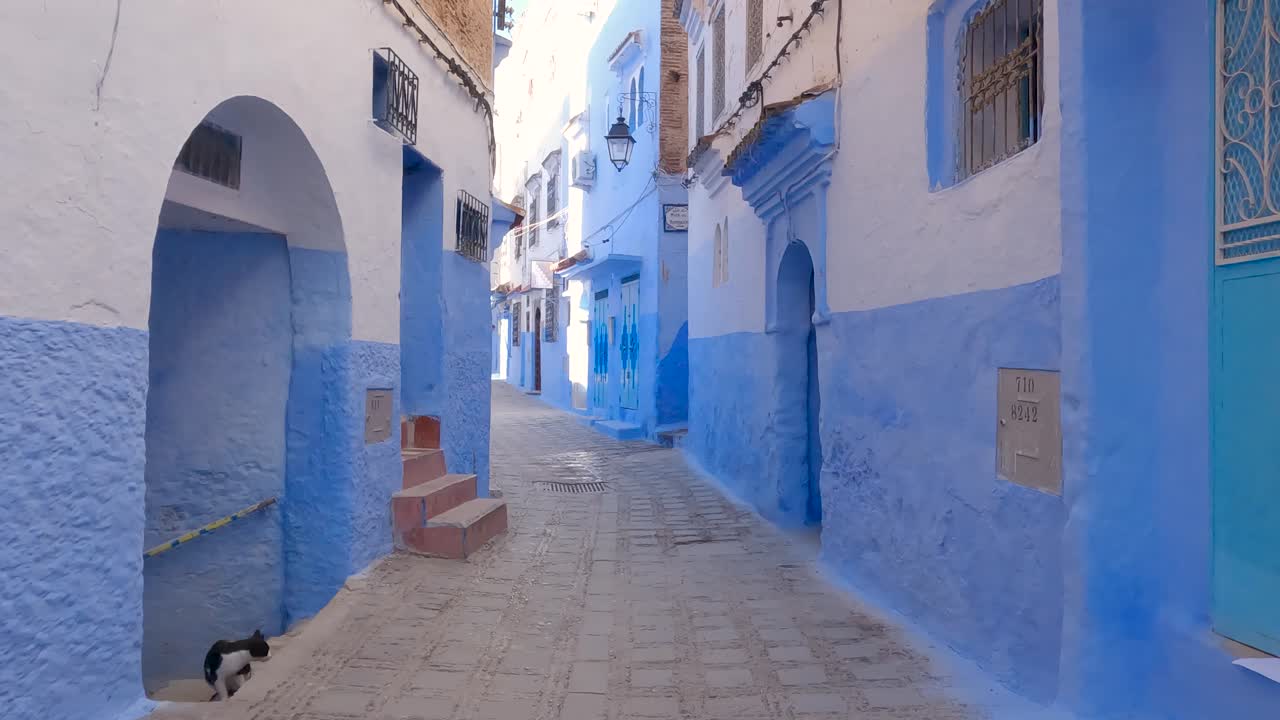 pov는 모로코의 쉐프샤우엔(chefchaouen)에 있는 빈 상징적인 파란색 페인트 거리를 따라 걷고 있습니다.