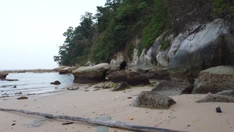 Un-Largo-Trozo-De-Madera-Ha-Sido-Varado-En-Una-Playa-Remota-En-Las-Islas-Andaman-Donde-Han-Caído-Rocas-Gigantes-Y-El-Bosque-Bordea-La-Orilla