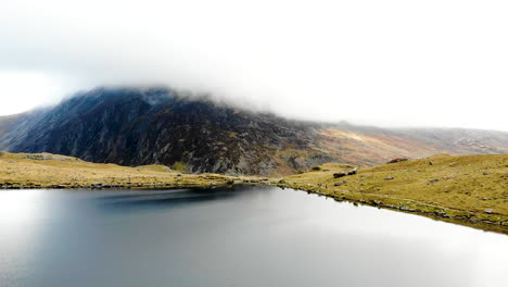 Aerial-footage-Cwm-Idwal,-beautiful-lake-in-Snowdonia-National-Park,-North-Wales-on-a-very-windy-day