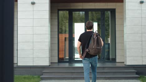 casual man entering modern office with backpack. modern man going up stairs