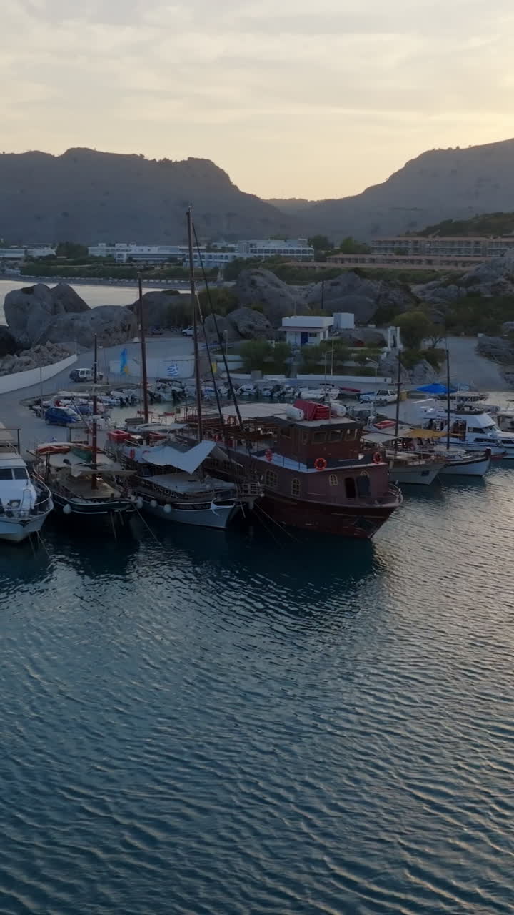 Vertical drone shot of boats at the Kolympia Harbor, sunset in Rhodes, Greece