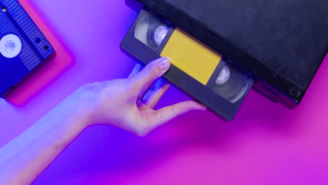 top view of video vhs device and cassette on lilac background