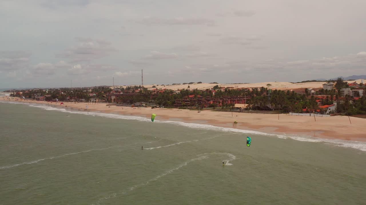 antena: cumbuco durante el día con gente haciendo kitesurf