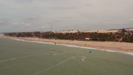 antena: cumbuco durante el día con gente haciendo kitesurf