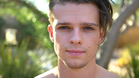 a fit young attractive white man smiling calmly while exhaling his breath during a reflective meditation session focusing on mindfulness, present awareness and positivity