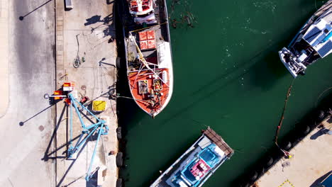 drone top down dolly over moored commercial fishing vessels at harbor