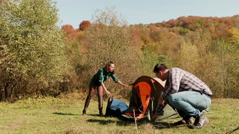 tourist and his girlfriend setting up the camping tent