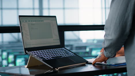 ingeniero de centro de datos codificando en el portátil, ajustando la configuración de energía