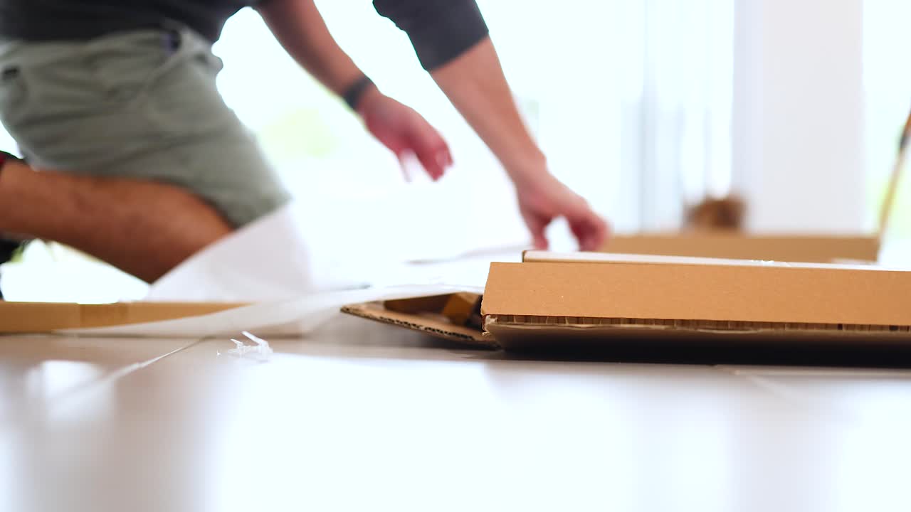 Person unpacks and assembles wooden furniture in a sunlit room, showcasing careful handling and assembly steps