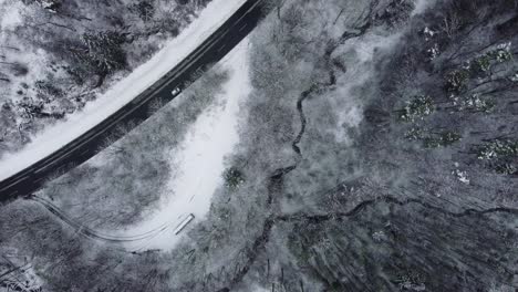 Road-leading-through-a-forest-covered-in-snow-during-winter