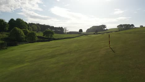 Aerial-Flyover-of-Golf-Course-Fairway,-Low-Fly-Along-Fairway-to-Reveal-Green-and-Pan-Back-Around-to-Tee,-Drone-Shot-on-Sunny-Day-in-Fife