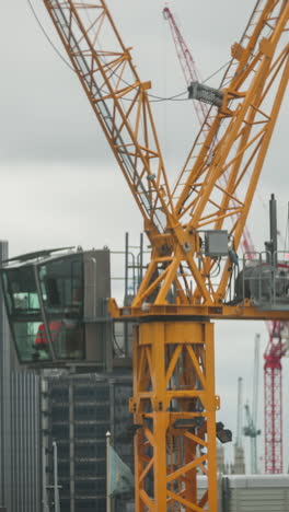 london, england - 31 august 2022 : london skyline with cranes building a high rise tower in vertical