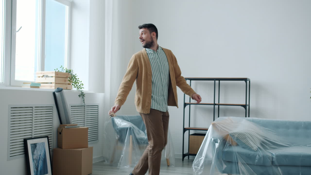 Happy Man Dancing in New Apartment