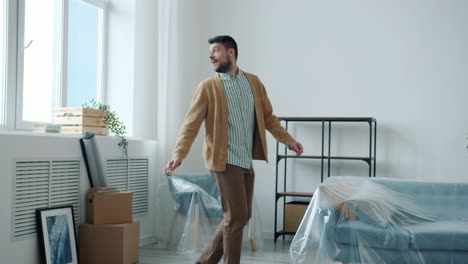 happy man dancing in new apartment