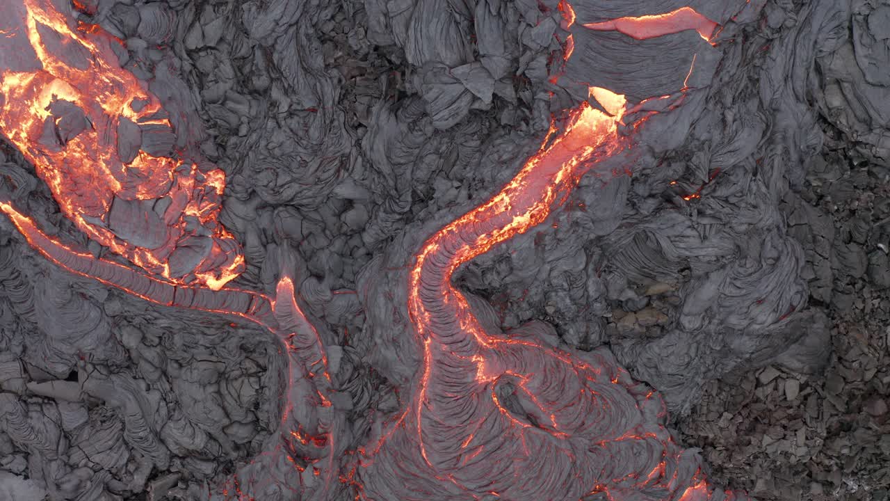 vista de arriba hacia abajo de la lava que fluye de la erupción del volcán fagradalsfjall en la península de reykjanes, sur de islandia - toma aérea de drones