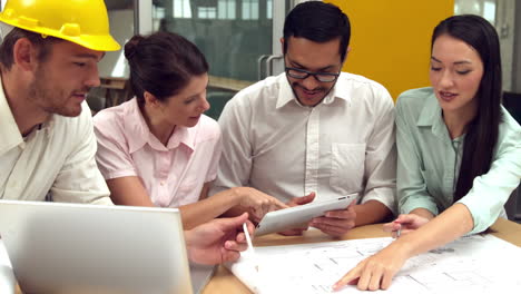 Equipo-De-Arquitectos-Revisando-Planos-Con-Tablet-Pc