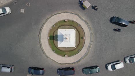 Overhead-drone-view-of-Tugu-Yogyakarta-Monument-in-crowded-traffic,-Indonesia