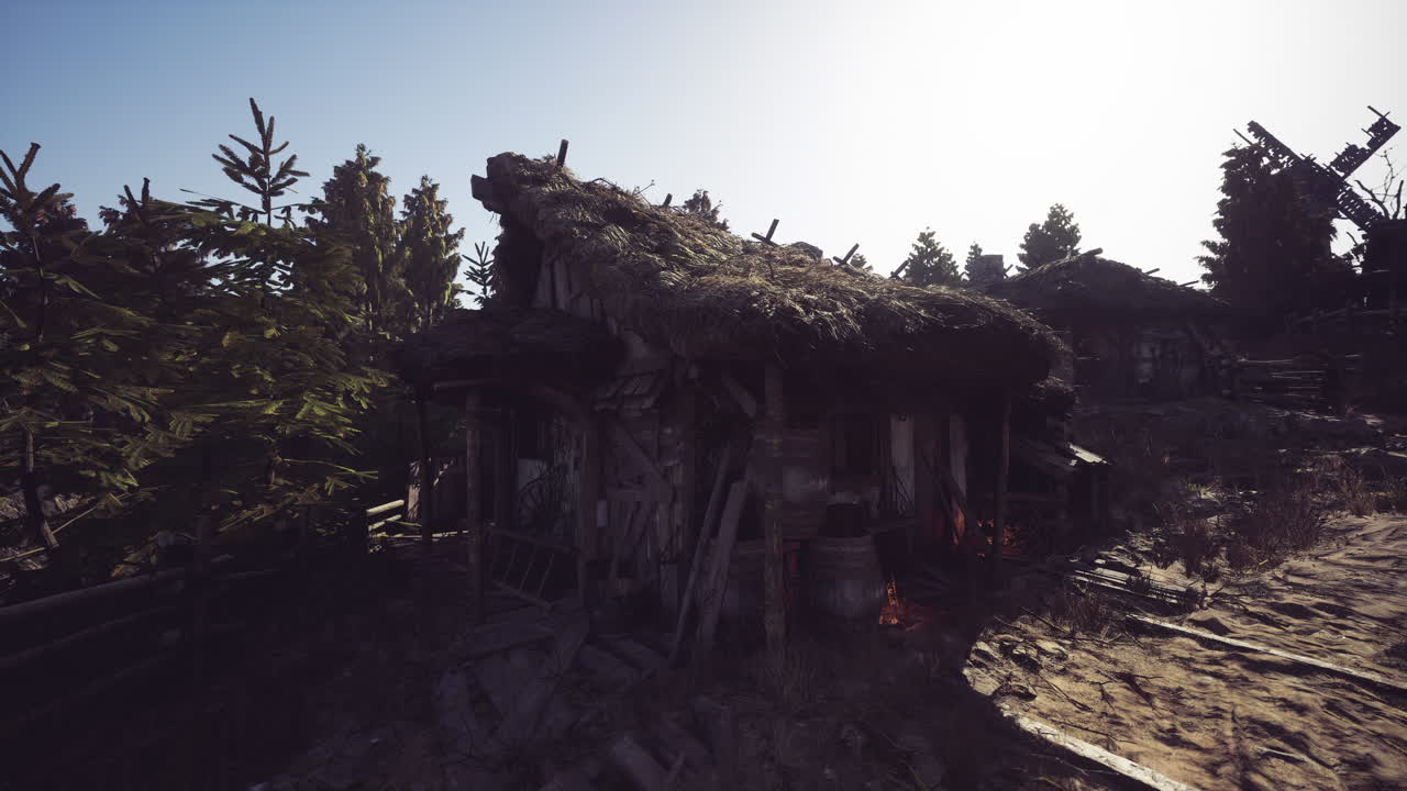 Abandoned rustic cabin surrounded by trees under a clear sky at sunrise