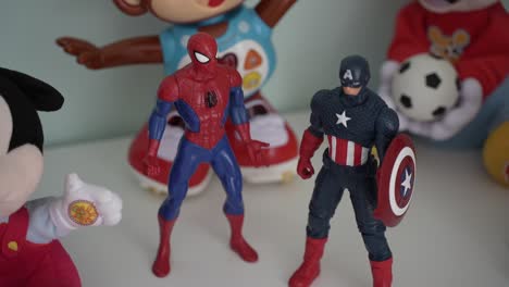 superhero figures amidst assorted kids' toys on a shelf