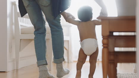 baby learning to walk toddler taking first steps with father helping infant teaching child at home