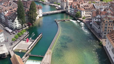 aerial of canal and revealing the city and a beautiful church in downtown luzern , switzerland